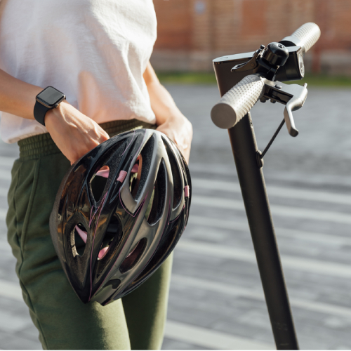 Frau mit Helm auf dem E-Scooter.