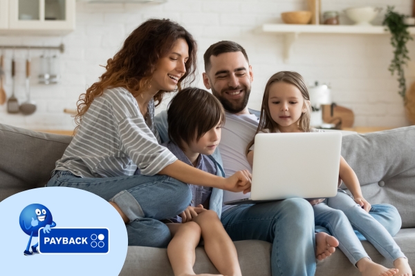 Familie vor einem Laptop auf der Couch.