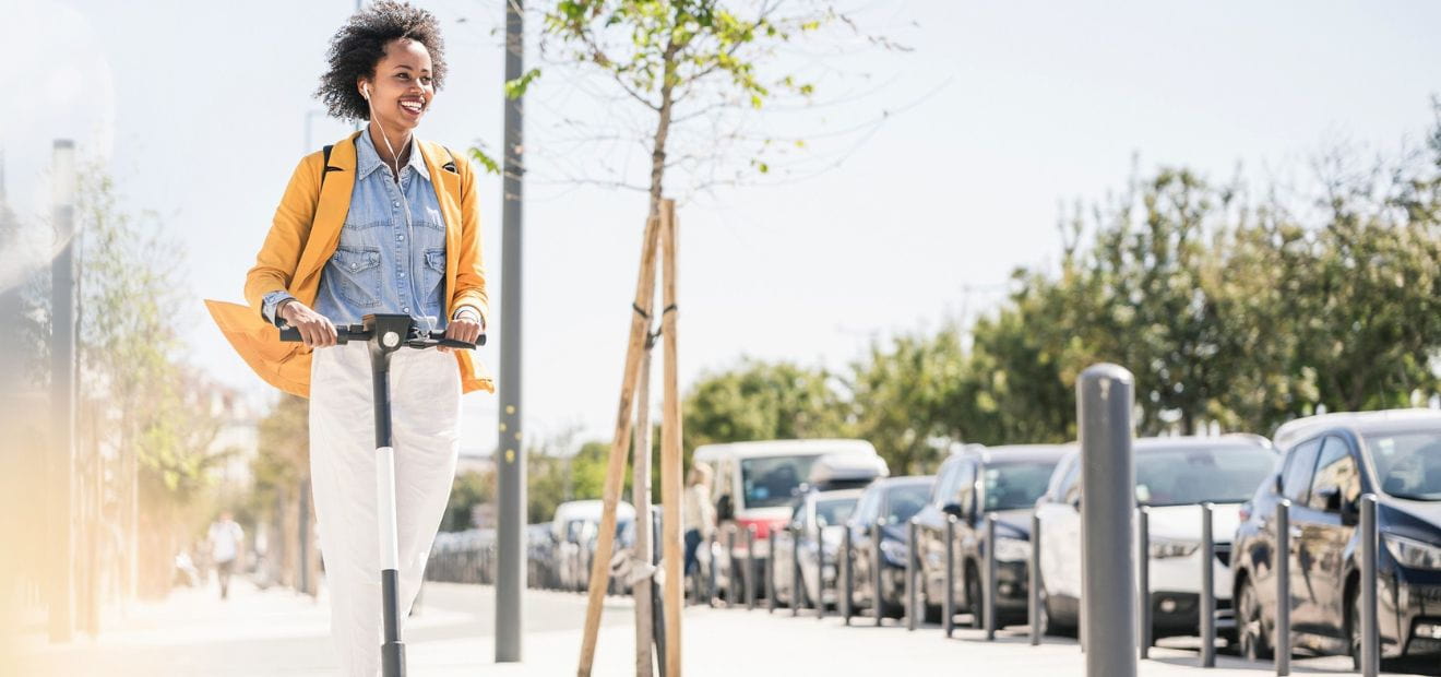 Frau auf E-Scooter: Die günstige E-Scooter-Versicherung von AdmiralDirekt.