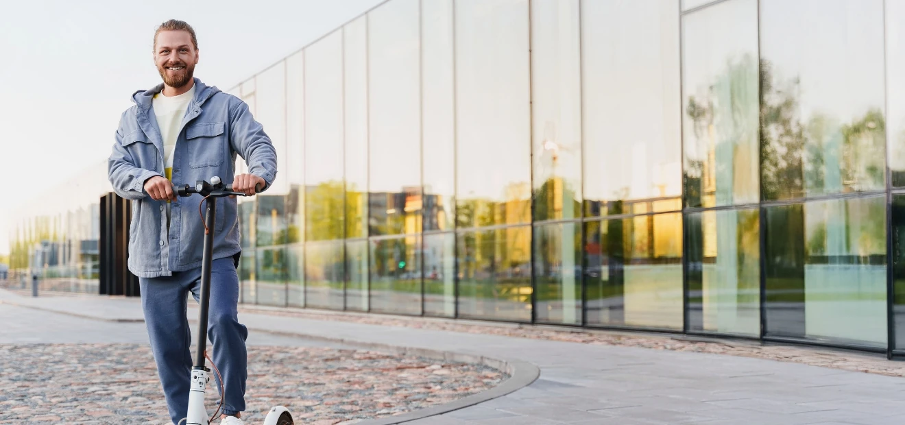 Mann auf E-Scooter: Die günstige E-Scooter-Versicherung von AdmiralDirekt.
