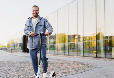Mann auf E-Scooter: Die günstige E-Scooter-Versicherung von AdmiralDirekt.