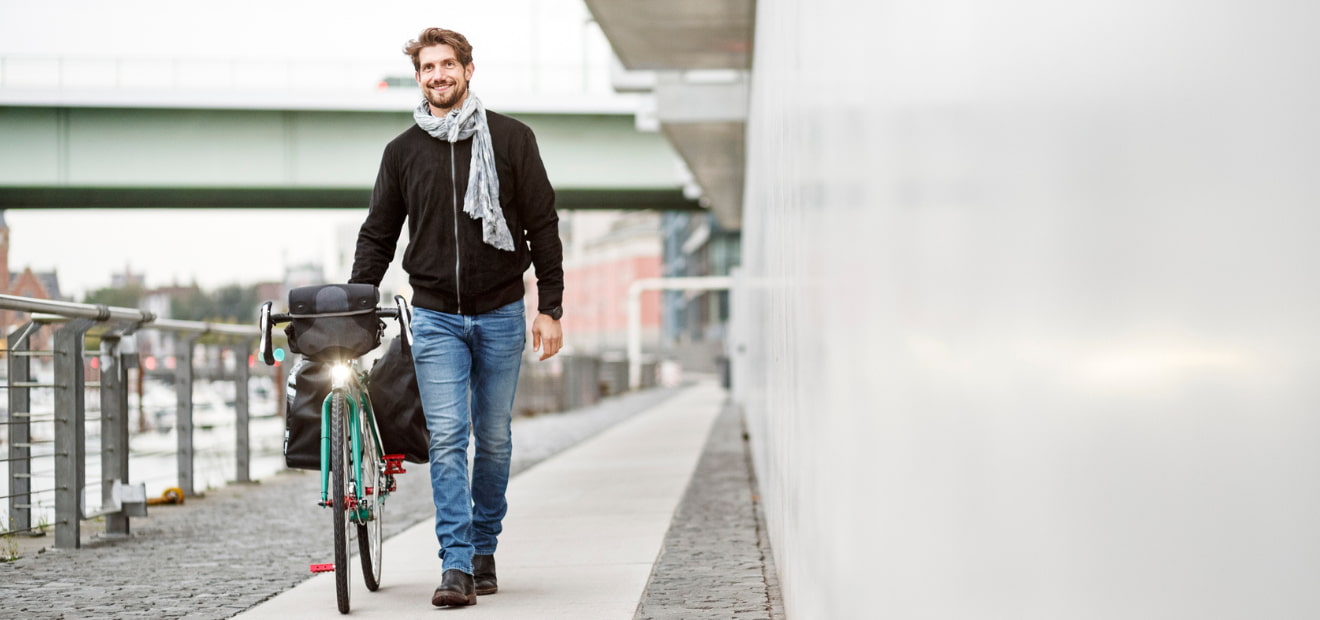 Ein Mann schiebt sein Fahrrad. 
