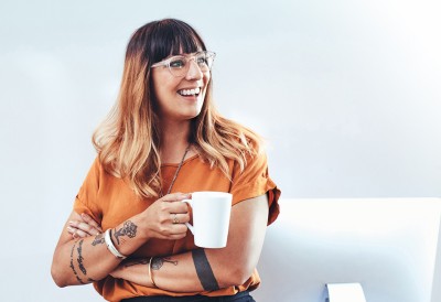 Lächelnde Frau mit Tasse in der Hand.