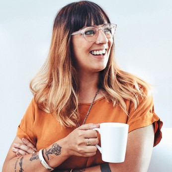 Lächelnde Frau mit Tasse in der Hand.