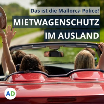 Vier Personen fahren in einem Cabrio und recken die Hände in die Luft. 