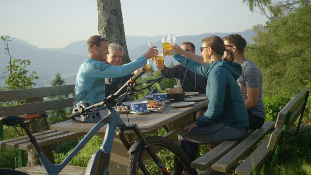 Freunde machen Pause von ihrer Radtour und trinken ein Bier. 