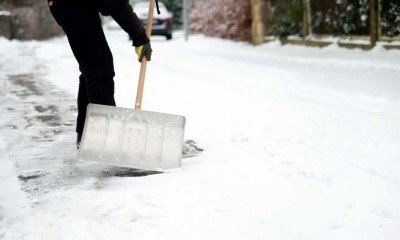 Mann räumt im Winter die Straße von Scnee frei. 