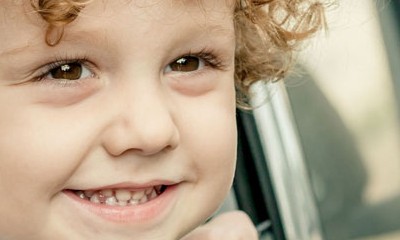 Ein glücklicher kleiner Junge schaut aus dem Auto.