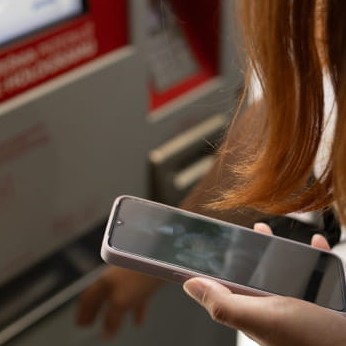 Frau kauft ein Bahnticket am Ticketautomat