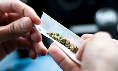 Ein Mann dreht einen Joint in einem Auto. 