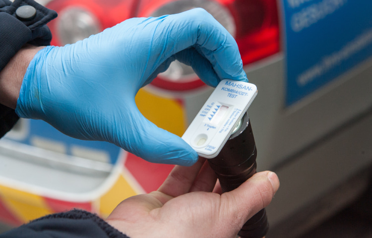 Polizist macht einen Drogen-Schnelltest bei einer Verkehrskontrolle.