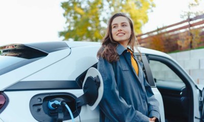 Frau lädt ihr E-Auto auf. 