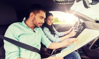 Junges Paar studiert seine Urlaubsroute. Die grüne Karte sollte immer dabei sein.