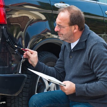 Gutachter prüft einen Schaden an einem Auto