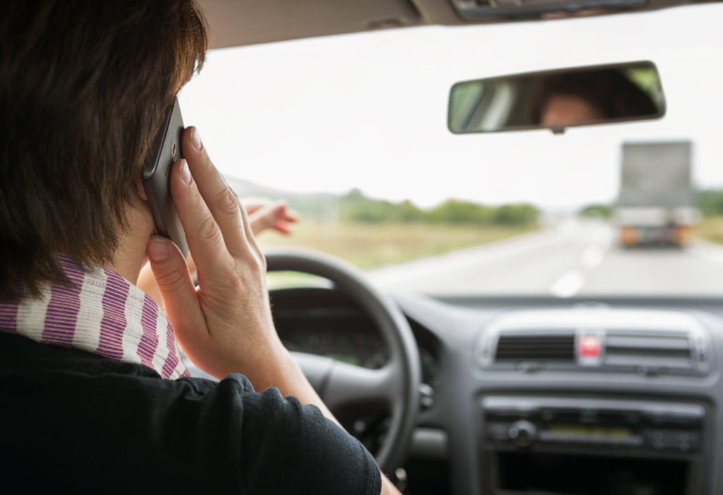 Frau telefoniert beim Autofahren
