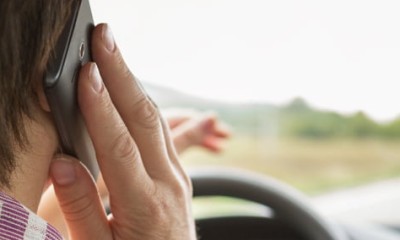 Frau telefoniert beim Autofahren