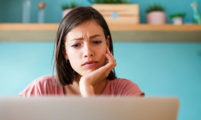 Junge Frau sitzt vor einem Laptop. 