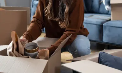 Eine Frau packt Umzugskartons in einer Wohnung.