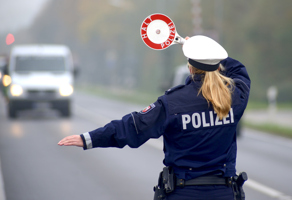 Eine Polizistin stoppt ein Fahrzeug für eine Verkehrskontrolle. 