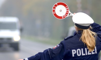 Eine Polizistin stoppt ein Fahrzeug für eine Verkehrskontrolle. 