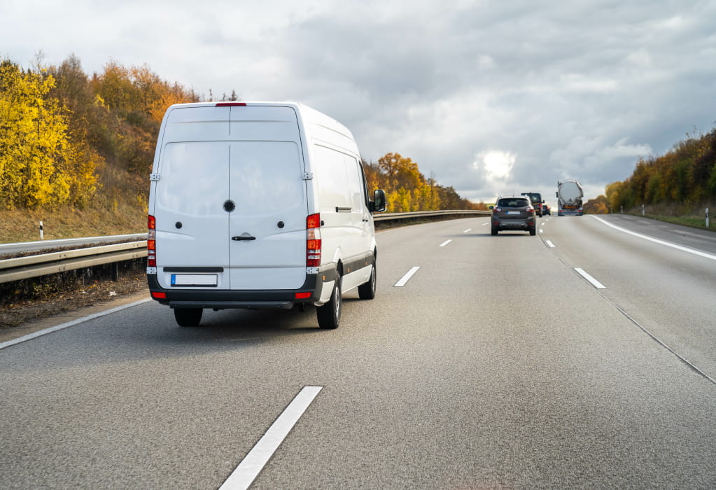 Ein Auto überholt einen Transporter von rechts auf der Autobahn. 