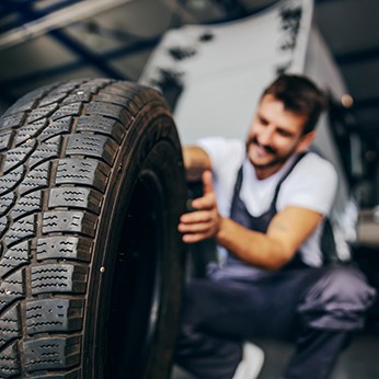 Mechaniker mit neuem Reifen.