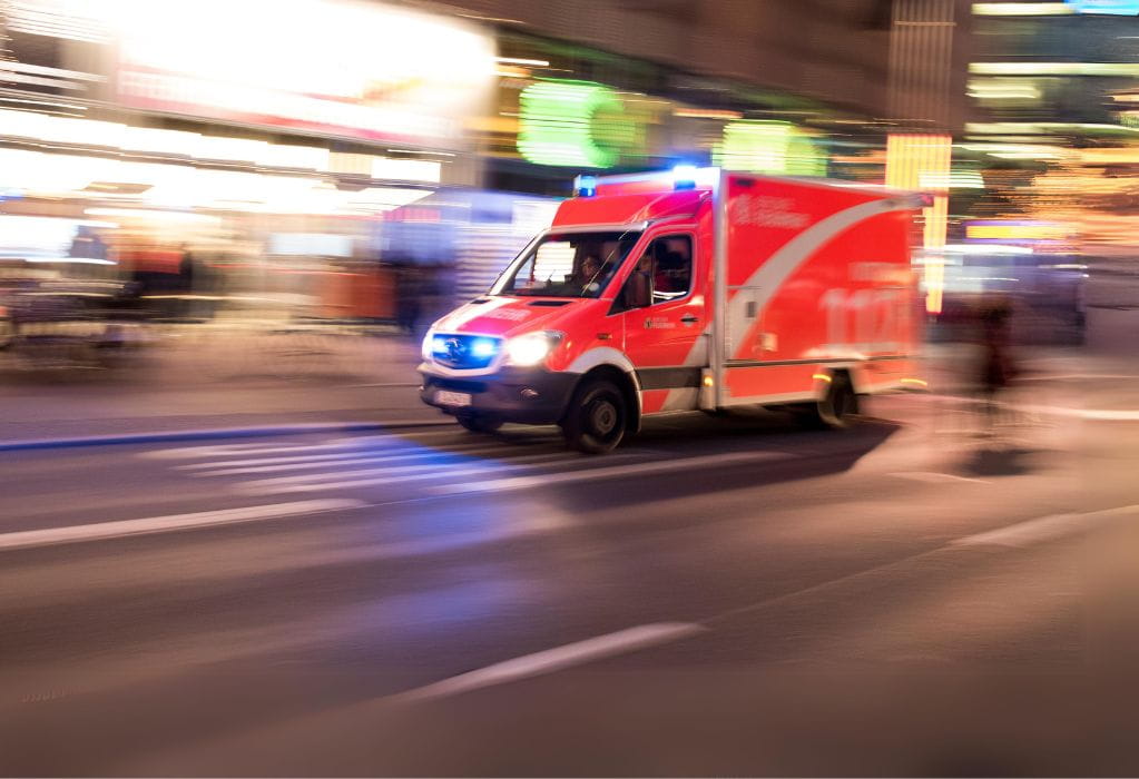 Rettungswagen fährt mit Blaulicht durch die Stadt