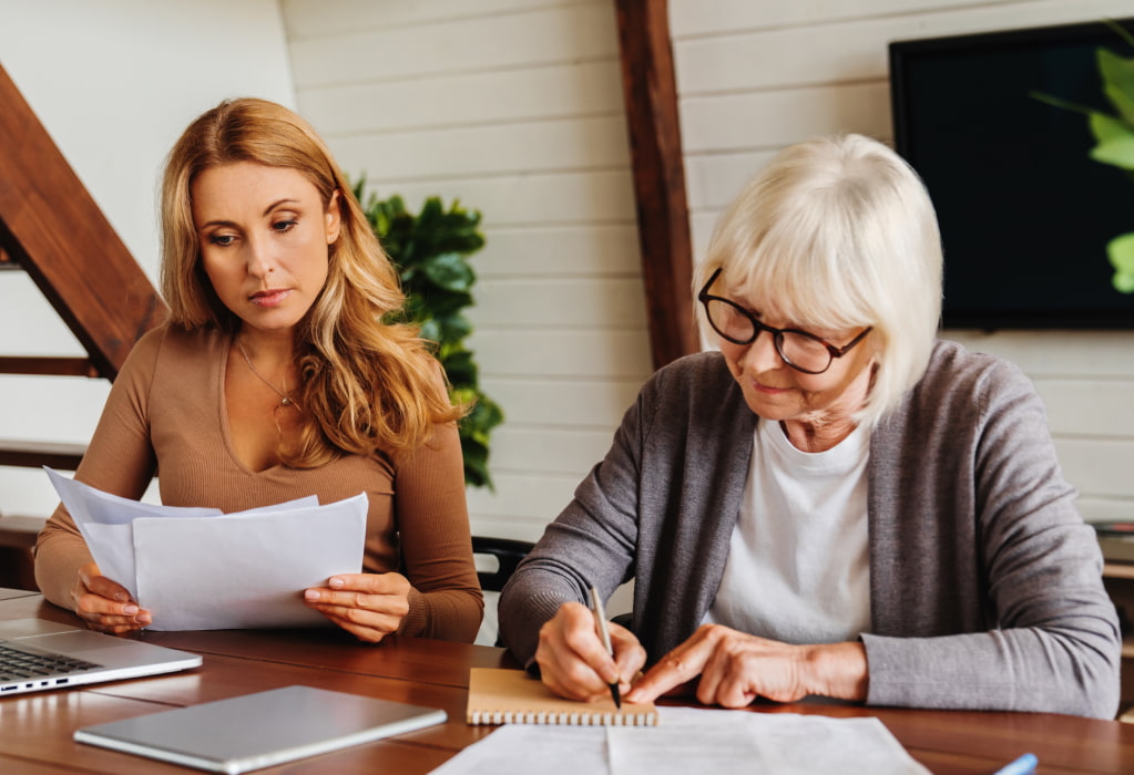 Eine ältere Frau und ihre Tochter kümmern sich um eine Vorsorgevollmacht. 